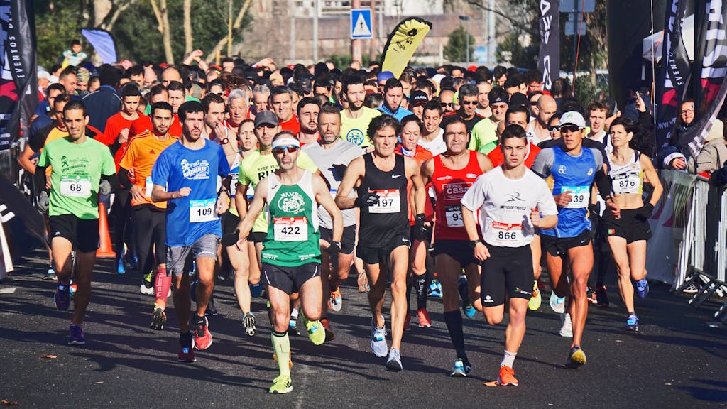 A large group of marathon runners competes outdoors in broad daylight, showcasing endurance and fitness.